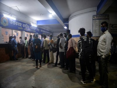 Des personnes font la queue pour acheter un billet d'autocar le 15 mai 2021 à Siliguri, en Inde, après que l'Etat du Bengale occidental a décrété un confinement de deux semaines pour freiner les contaminations - Diptendu DUTTA [AFP]