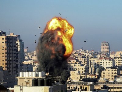 Une boule de feu et de la fumée s'élèvent dans le ciel après une frappe aérienne israélienne sur la ville de Gaza visant le complexe Ansar, lié au mouvement Hamas, dans la bande de Gaza, tôt le 15 mai 2021 - MOHAMMED ABED [AFP]