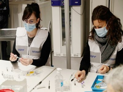 Des infirmières préparent des doses de vaccin Pfizer-BioNTech au centre de vaccination Porte de Versailles, au sud de Paris, le 15 mai 2021 - GEOFFROY VAN DER HASSELT [AFP]