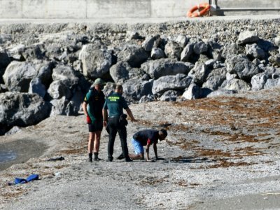 La garde civile espagnole avec un migrant qui vient d'arriver à la nage dans l'enclage de Ceuta, depuis le Maroc voisin, le 17 mai 2021 - Antonio Sempere [AFP]