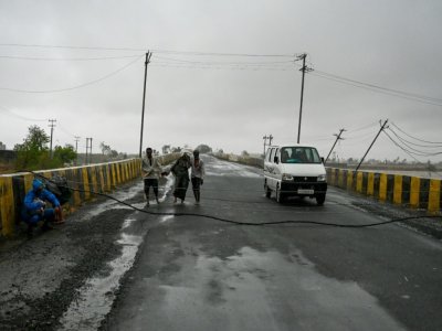 Des câbles électriques tombés au sol sur un pont de Diu, après le passage du cyclone Tauktae, le 18 mai 2021 en Inde - Punit PARANJPE [AFP]