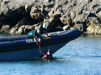 Des gardes civils espagnols hissent un migrant à bord d'un bateau à son arrivée dans l'enclave espagnole de Ceuta, le 17 mai 2021 - Antonio Sempere [AFP]
