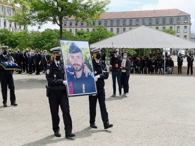 Des policiers portent un portrait de leur collègue Eric Masson lors d'une cérémonie d'hommage à Avignon le 11 mai 2021 - Nicolas TUCAT [POOL/AFP]