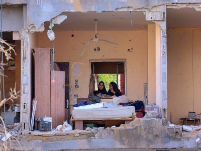 Des Palestiniennes dans les ruines d'un bâtiment détruit par les frappes israéliennes, à Beit Hanun, dans le nord de la bande de Gaza, le 21 mai 2021 - Emmanuel DUNAND [AFP]