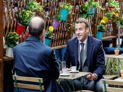 Le président français Emmanuel Macron (d) et le Premier ministre français Jean Castex prennent un café sur une terrasse éphémère à Paris, le 19 mai 2021 - GEOFFROY VAN DER HASSELT [AFP/Archives]