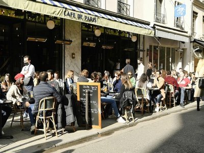 Des clients installés au soleil à une terrasse de café à Paris, le 19 mai 2021 - Bertrand GUAY [AFP/Archives]
