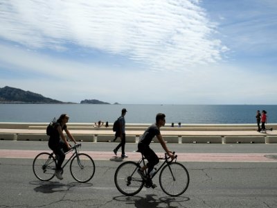 Des promeneurs à pied ou à vélo sur la route de la Corniche à Marseille le 23 mai 2021 - Nicolas TUCAT [AFP]