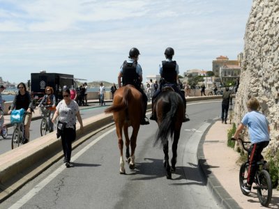 Des policiers à cheval en patrouille sur la route de la Corniche à Marseille le 23 mai 2021 - Nicolas TUCAT [AFP]