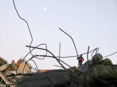 Un Palestinien sur les ruines d'un immeuble détruit par un bombardement israélien à Gaza, le 24 mai 2021 - MOHAMMED ABED [AFP]