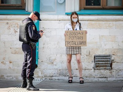Une femme venue seule manifeste sa solidarité avec le journaliste bélarusse emprisonné Roman Protassevitch en tenant une pancarte réclamant sa libération, devant l'ambassade du Bélarus à Moscou le 25 mai 2021 - Dimitar DILKOFF [AFP]