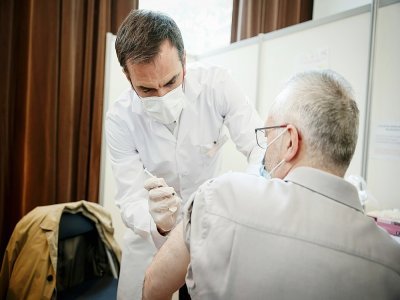 Le ministre de la Santé Olivier Véran vaccine un patient au centre de vaccination de Montrouge, le 11 mai 2021 - Thomas Padilla [POOL/AFP/Archives]