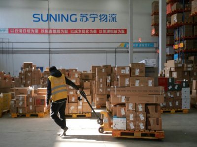 Un employé transfère des colis à livrer à l'entrepôt de Suning Logistics Network, à Shenyang en Chine, le 11 novembre 2020 - STR [AFP/Archives]