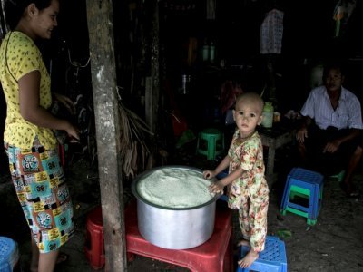 Un enfant devant une marmite de riz distribué par le PAM à Rangoun le 21 mai 2021 - STR [AFP]