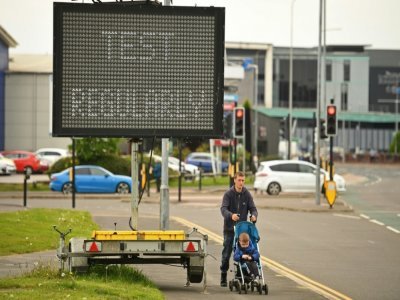 Un panneau d'affichage électronique enjoint au public de se faire tester à Bolton (nord-ouest de l'Angleterre), touchée par un variant du Covid-19, le 28 mai 2021 - Oli SCARFF [AFP]