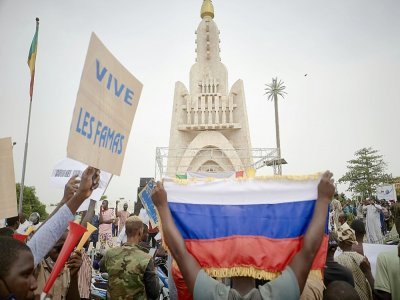 Des partisans du coup d'Etat au Mali brandissent un drapeau russe lors d'une manifestation à Bamako le 28 mai 2021 - Michele Cattani [AFP]