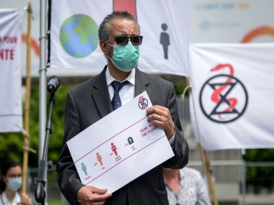 Le directeur général de l'OMS, Tedros Adhanom Ghebreyesus, tient une pétition lui ayant été remise par des manifestants, le 29 mai 2021 à Genève - Fabrice COFFRINI [AFP]