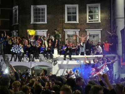 Des supporters de Chelsea célèbrent la victoire en montant sur des balcons le 29 mai 2021 à Londres - DANIEL LEAL-OLIVAS [AFP]
