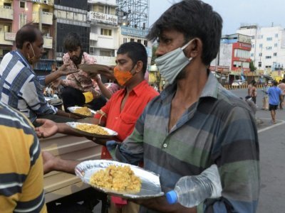 Des volontaires d'une ONG distribuent de la nourriture à Secunderabad, la ville jumelle de Hyderabad en Inde le 29 mai 2021 - NOAH SEELAM [AFP]