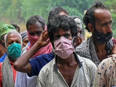 Des Indiens sans domicile fixe, notamment des travailleurs journaliers, font la queue lors d'une distribution de nourriture à New Delhi le 20 mai 2021 - Prakash SINGH [AFP]