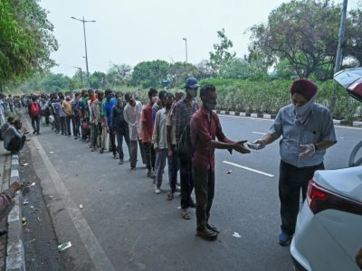 Des Indiens sans domicile fixe et qui ont pour la plupart perdu leur emploi font la queue lors d'une distribution de nourriture à New Delhi le 20 mai 2021 - Prakash SINGH [AFP]