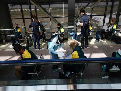 Les joueuses de l'équipe australienne de softball attendent le résutat de leur test anti-covid à leur arrivée à l'aéroport de Narita (Japon) le 1er juin 2021 - Behrouz MEHRI, Behrouz MEHRI [POOL/AFP]