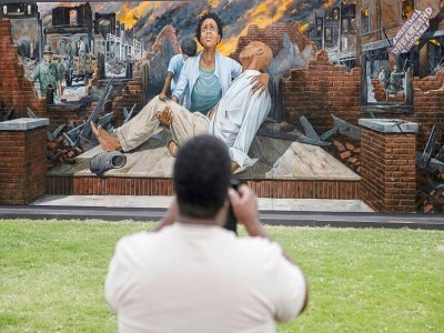 Un homme photographie une oeuvre murale en hommage aux victimes du massacre de 1921 à Tulsa, dans l'Oklahoma, le 31 mai 2021 - ANDREW CABALLERO-REYNOLDS [AFP]