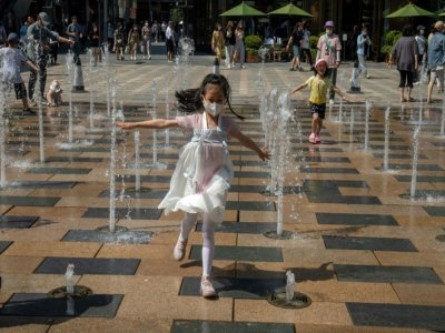 Des enfants jouent dans une fontaine devant un centre commercial de Pékin, le 1er juin 2021 en Chine - NICOLAS ASFOURI [AFP]