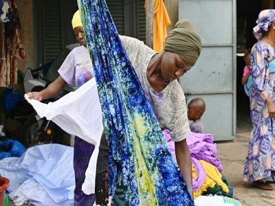 Des femmes teignent des tissus de coton pour le couturier ivoiro-burkinabè Pathé'O à Abidjan, le 31 mai 2021 - Issouf SANOGO [AFP]