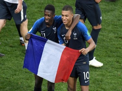 Ousmane Dembélé et Kylian Mbappé posent avec le drapeau français après la victoire en finale de la Coupe du monde le 15 juillet 2018 à Moscou - GABRIEL BOUYS [AFP/Archives]