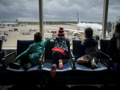 Des enfants de migrants du Honduras et du Salvador (d), en escale à l'aéroport de Houston, le 30 mars 2021, quelques jours après avoir traversé le Rio Grande - Ed JONES [AFP]