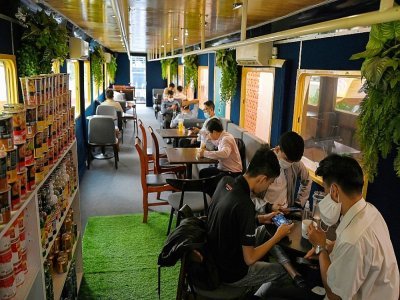 Des clients dans un wagon de train reconverti en café, le 31 mai 2021 à Phnom Penh, au Cambodge - TANG CHHIN Sothy [AFP]