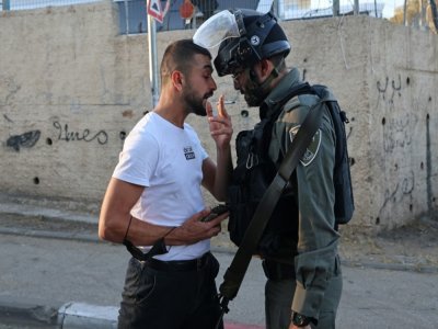 Un Palestinien et un membre des forces de sécurité israéliennes se font face à Cheikh Jarrah, quartier de Jérusalem-Est occupé et annexé par Israël, le 15 mai 2021 - EMMANUEL DUNAND [AFP/Archives]