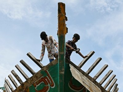 Des ouvriers travaillent sur un bateau de pêche dans le port de Kasimedu, le 10 juin 2021 en Inde - Arun SANKAR [AFP]