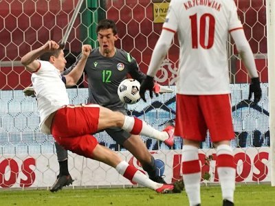 L'attaquant polonais Robert Lewandowski marque contre le gardien d'Andorre Iker, lors des qualifications pour le Mondial 2022 au Qatar, le 28 mars 2021 à Varsovie - JANEK SKARZYNSKI [AFP/Archives]