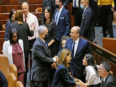 (G à D) L'ex-Premier ministre Benjamin Netanyahu serre la main à son successeur Naftali Bennett au Parlement à Jérusalem, le 13 juin 2021 - EMMANUEL DUNAND [AFP]