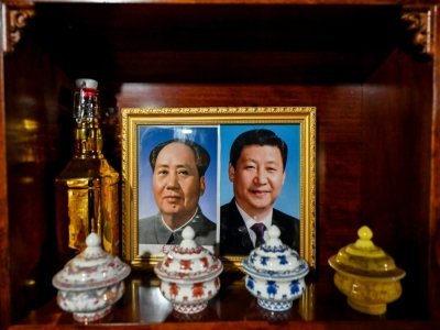 Des portraits de Mao Zedong et du président Xi Jinping chez Cangjie qui a ouvert des chambres d'hôte à Tashigang, au Tibet, le 4 juin 2021 - Hector RETAMAL [AFP]