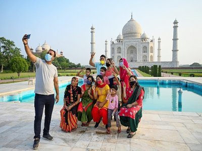 Un groupe de touristes prend des photos devant le Taj Mahal au premier jour de sa réouverture à Agra en Inde le 16 juin 2021 - Money SHARMA [AFP]