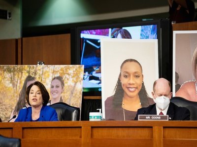 Les sénateurs démocrates américains Amy Klobuchar et Chris Coons présentent des photos de bénéficiaires de la loi Obamacare au Congrès à Washington le 12 octobre 2020 - Erin SCHAFF [POOL/AFP]