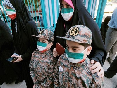 Une Iranienne accompagné de ses deux garçons portant des uniformes de l'armée d'élite du régime iranien, attend de voter à Téhéran, le 18 juin 2021 - MORTEZA NIKOUBAZL [AFP]