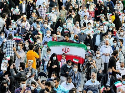 Des partisans du nouveau président iranien élu Ebrahim Raïssa fêtent sa victoire, le 19 juin 2021 à Téhéran - ATTA KENARE [AFP]