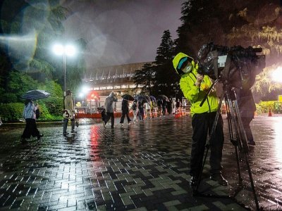Un journaliste près du village olympique à Tokyo, le 20 juin 2021 - Philip FONG [POOL/AFP]