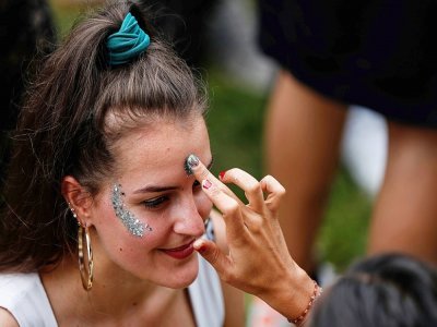 Une femme se fait maquiller pendant la Fête de la musique au parc Villemin, près du Canal Saint-Martin à Paris, le 21 juin 2020 - Abdulmonam Eassa [AFP/Archives]
