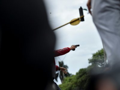Un homme utilise une arme à feu lors d'affrontements entre la police et des manifestants anti-gouvernementaux à Cali le 28 mai 2021 - Luis ROBAYO [AFP]