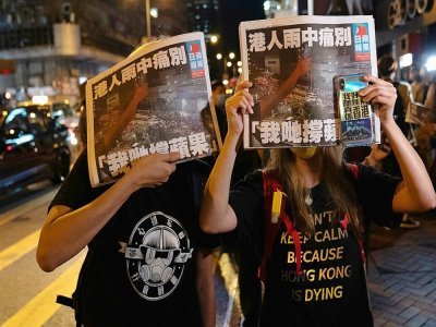 Deux femmes tiennent le dernier numéro du Apple Daily à Hong Kong, le 24 juin 2021 - Bertha WANG [AFP]