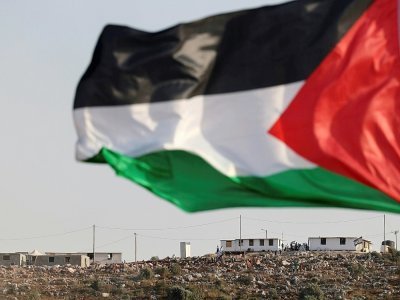 Un drapeau palestinien flotte dans le village de Beita  face à la colline sur laquelle est installée une colonie "sauvage" Eviatar en Cisjordanie occupée, le 13 juin 2021 - JAAFAR ASHTIYEH [AFP]