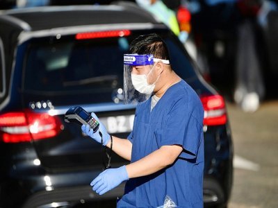 Un soignant dans un centre de test en drive-in dans le quartier de la plage de Bondi à Sydney, le 25 juin 2021 - SAEED KHAN [AFP]