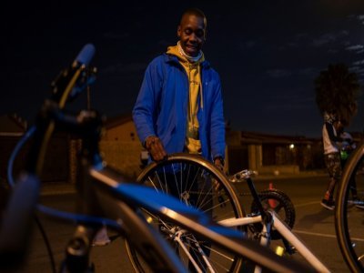 Un Biking Bandit répare son fixie avant la course, à Soweto le 24 juin 2021 - Emmanuel Croset [AFP]