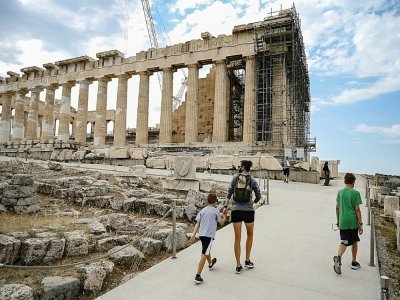 Des touristes visitent le temple du Parthénon sur l'Acropole à Athènes, le 4 juin 2021 - Aris MESSINIS [AFP/Archives]