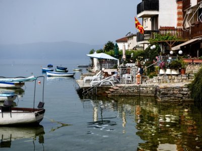 Des habitants prennent le soleil sur les rives du lac Ohrid, le 22 juin 2021 en Macédoine du Nord - Robert ATANASOVSKI [AFP]