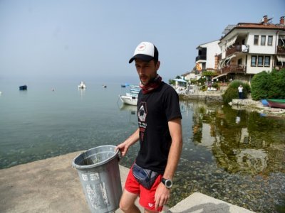 Nikola Paskali, plongeur et archéologue, ramasse des déchets sur la plage près du lac Ohrid, le 22 juin 2021 en Macédoine du Nord - Robert ATANASOVSKI [AFP]